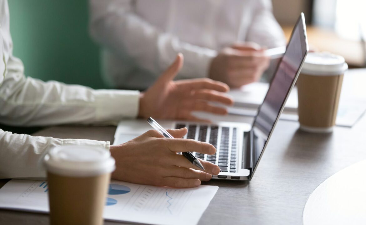 Businesswoman using laptop presenting project report at business