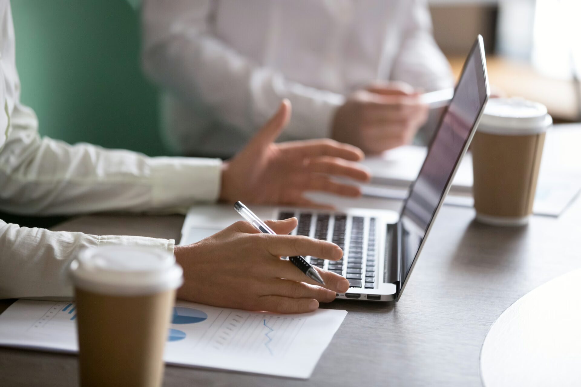 Businesswoman using laptop presenting project report at business