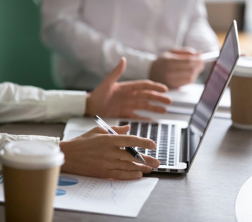 Businesswoman using laptop presenting project report at business